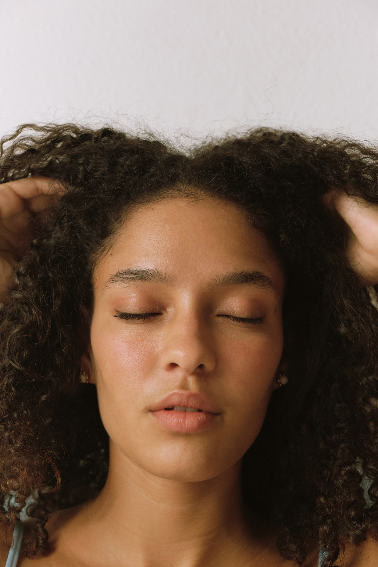 woman with curly hair massaging head