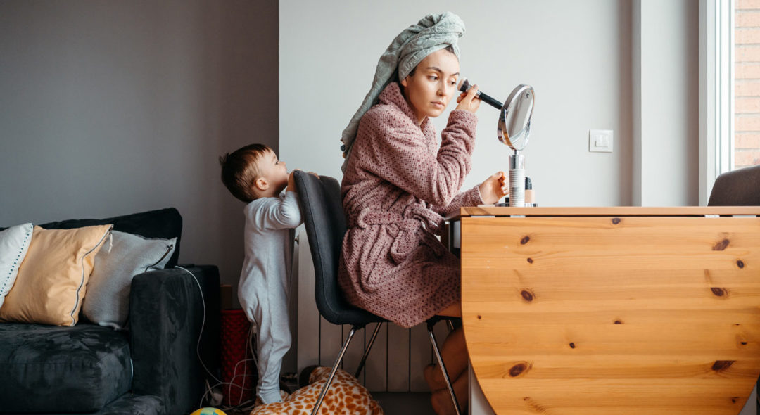 baby watching after mother doing makeup