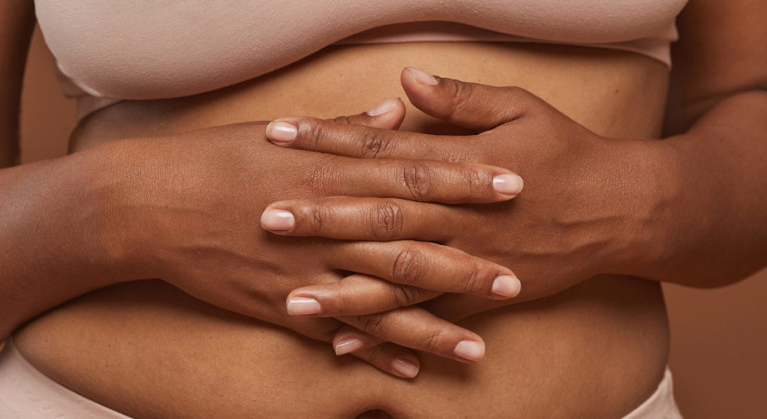 Close-up of woman in underwear holding stomach