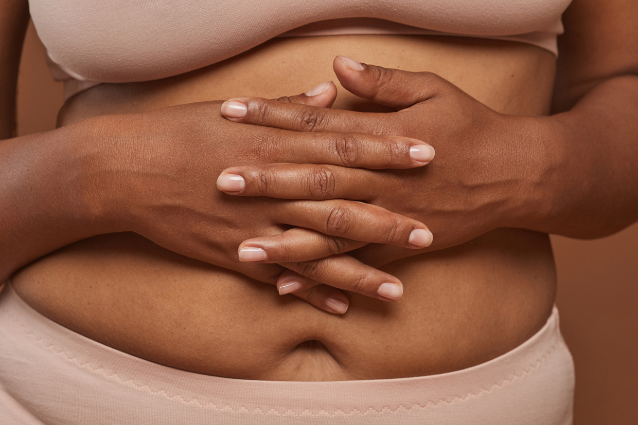 Close-up of woman in underwear holding stomach
