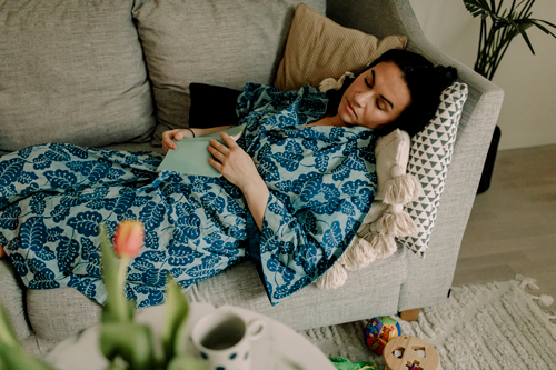Woman resting on sofa in living room