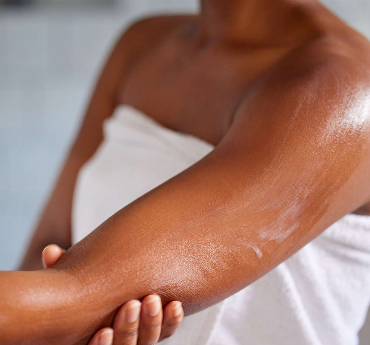 Shot of a woman massaging lotion into her skin