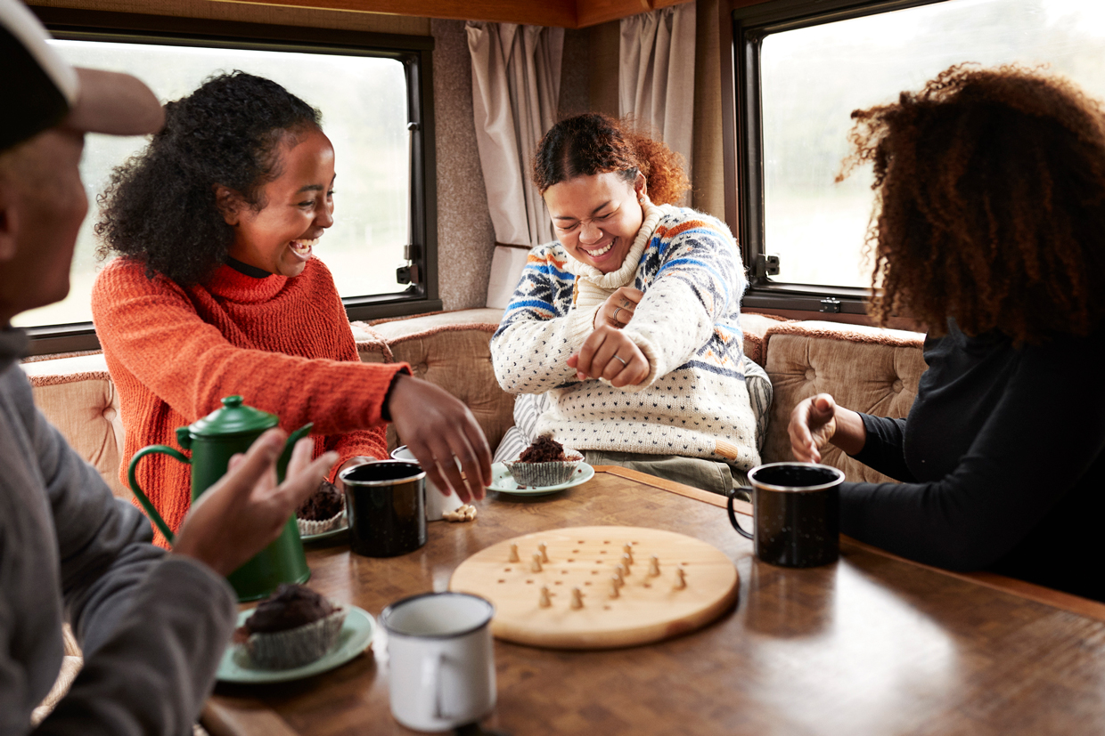 Friends having fun while playing board in motor home