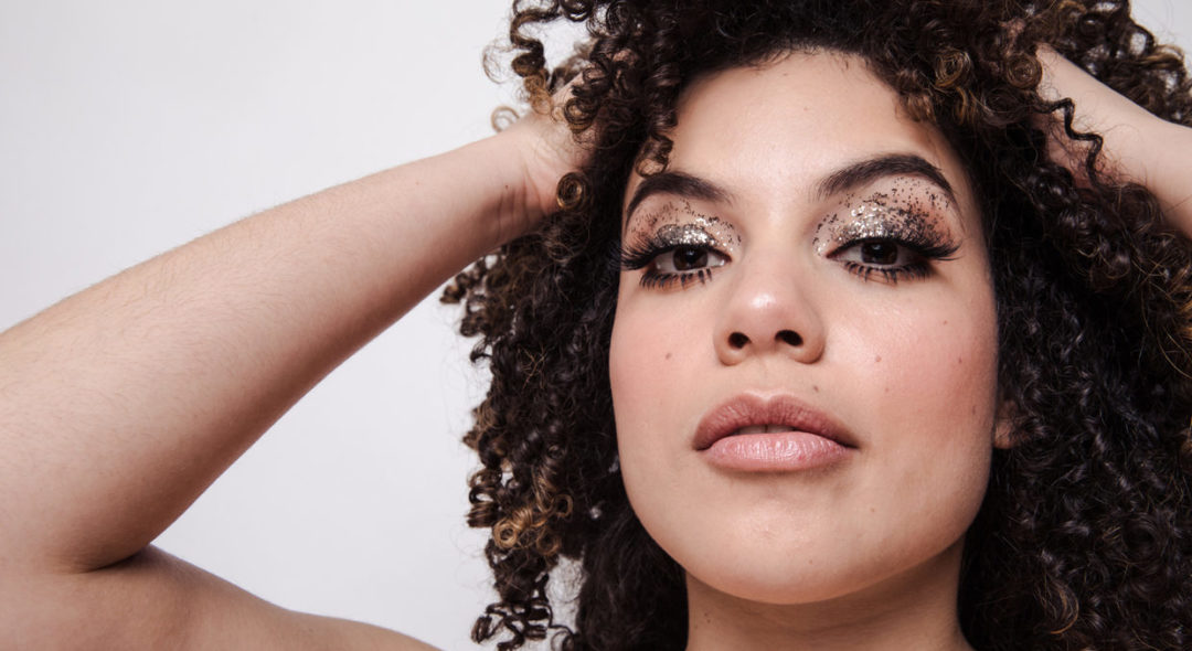 woman with curly hair and sparkly eyeshadows