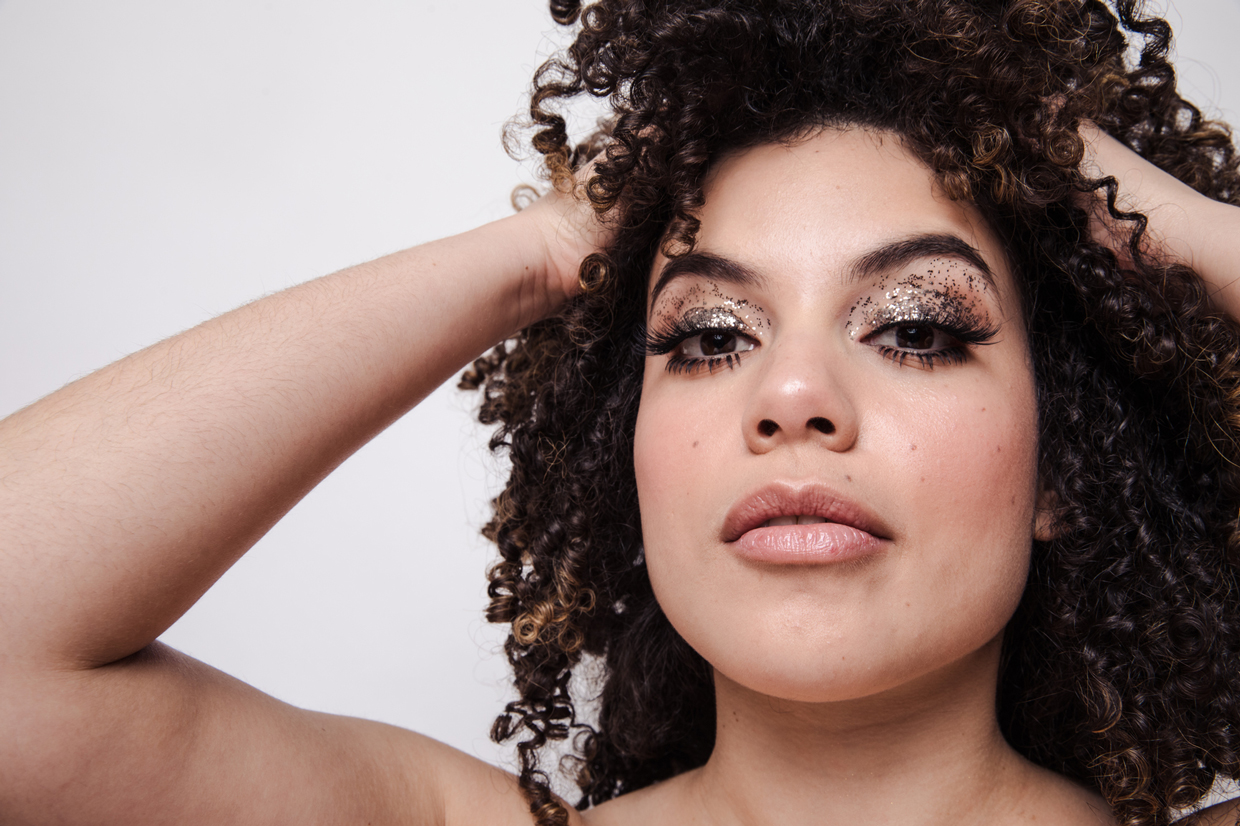 woman with curly hair and sparkly eyeshadows
