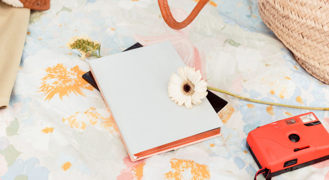 Spring items and book on a picnic blanket