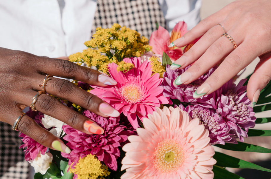 hands with nail art touching flowers