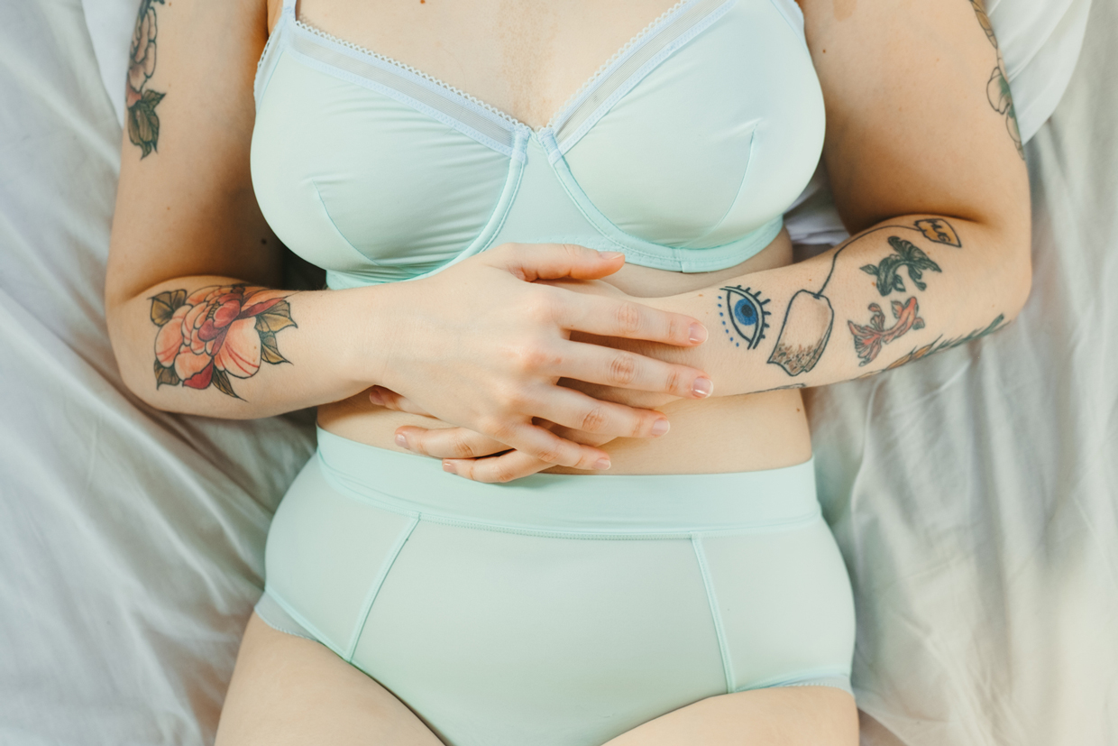woman with tattoos wearing mint underwear