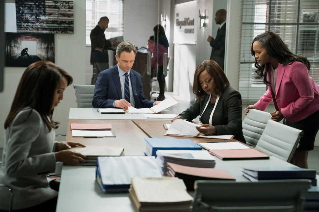 Still of Scandal series, Olivia Pope looking over documents with team