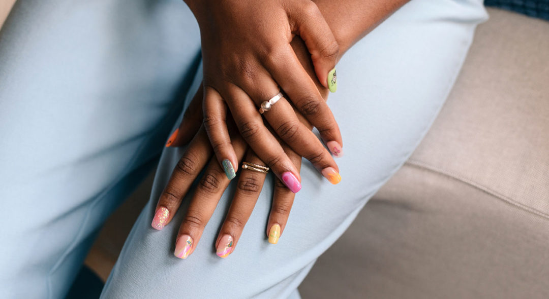 woman with colorful nails sitting down