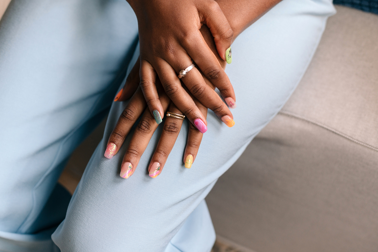 woman with colorful nails sitting down