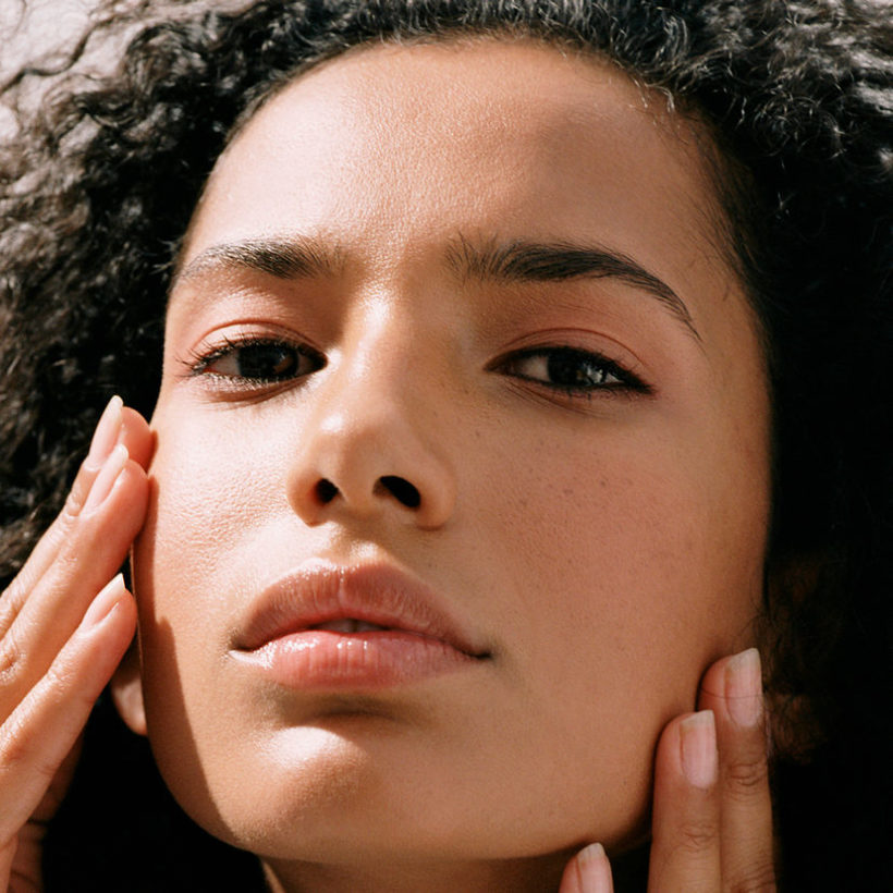 close up of woman touching face