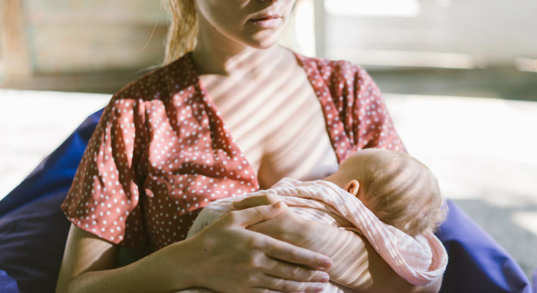 Little baby sucking breast of mother