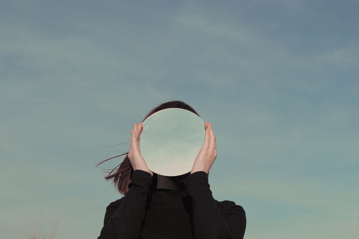 Woman Holding Mirror Against Sky