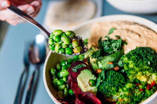 vegan bowl with edamame beans, broccoli, avocado, beetroot, hummus and nuts