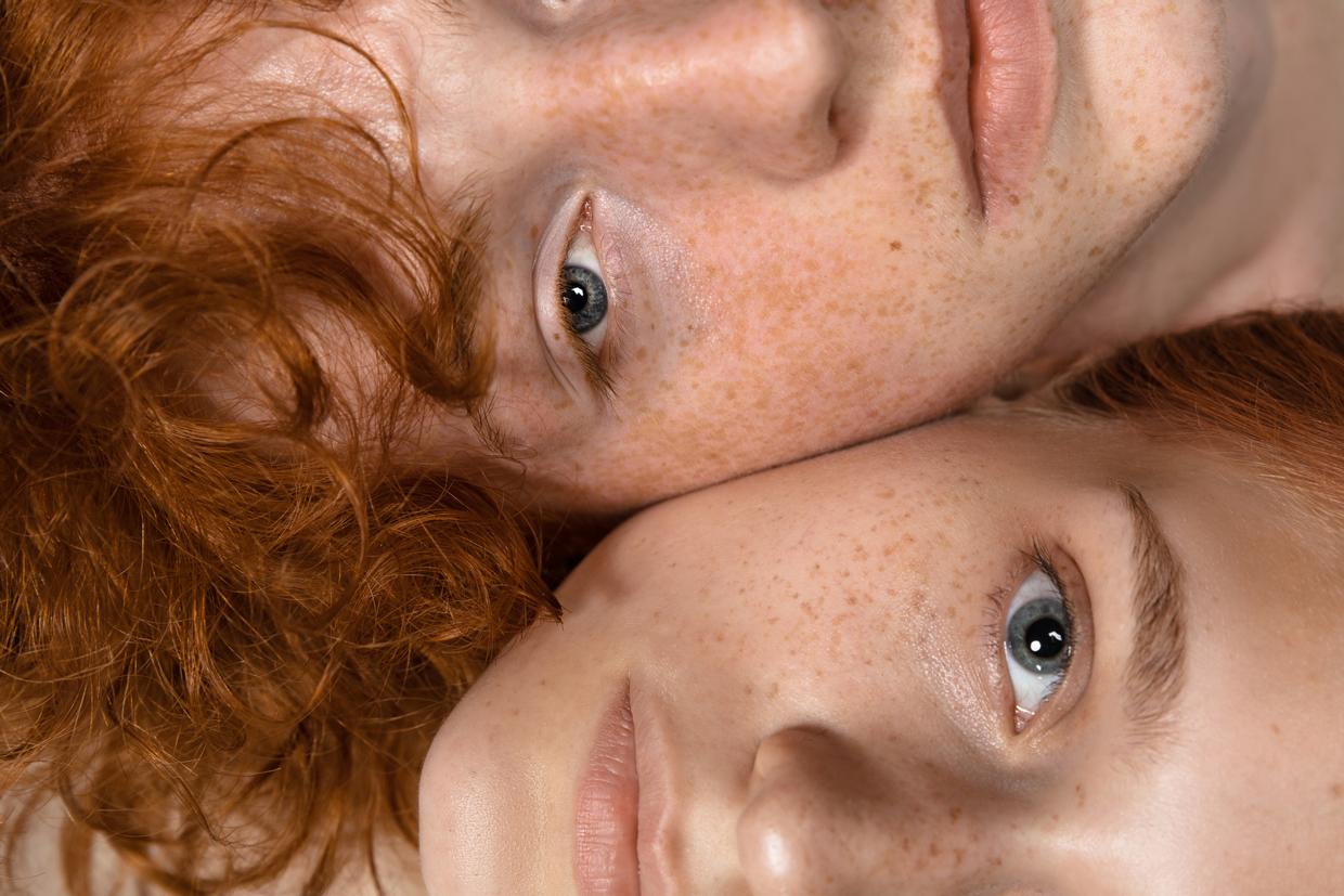 Portrait of two redheaded women isolated on grey studio background