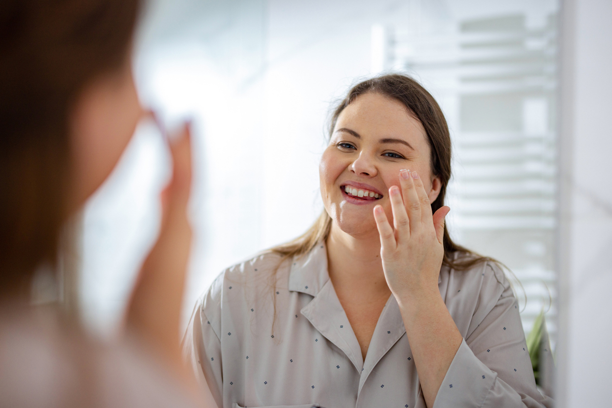 Woman Applying Face Cream on her Face in the Morning