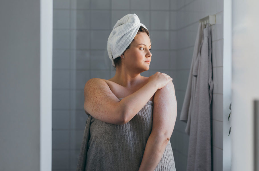 Woman Applying Body Lotion after Taking a Shower