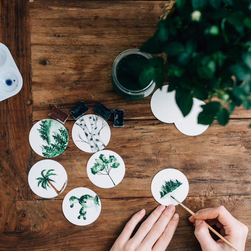 Cropped Hands Of Woman Doing Aquarelle At Wooden Table