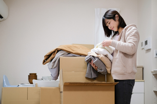 Woman sorting clothes in cardboard boxes