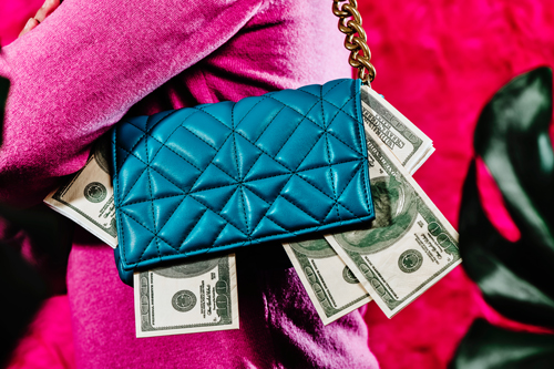 Woman Carries a blue purse full of fake dollar bills