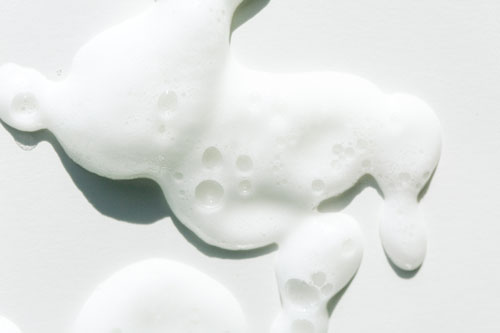 Smears of white foam on white background