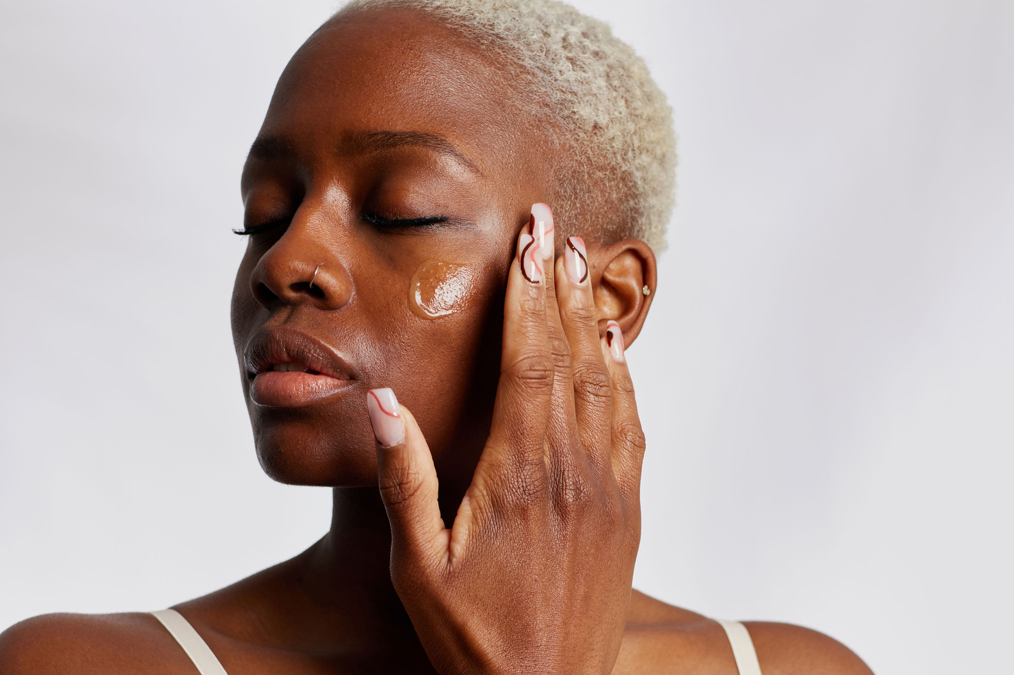 woman applying skincare to face
