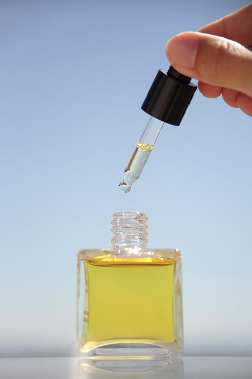 hand holding Bottle of beauty oil