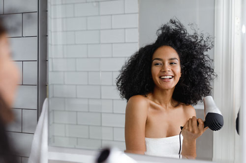Woman Drying Hair Reflecting On Mirror