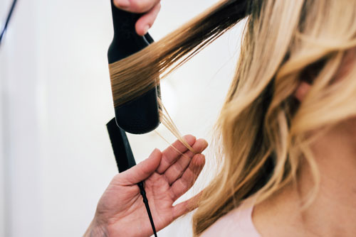 woman getting her hair heat styled
