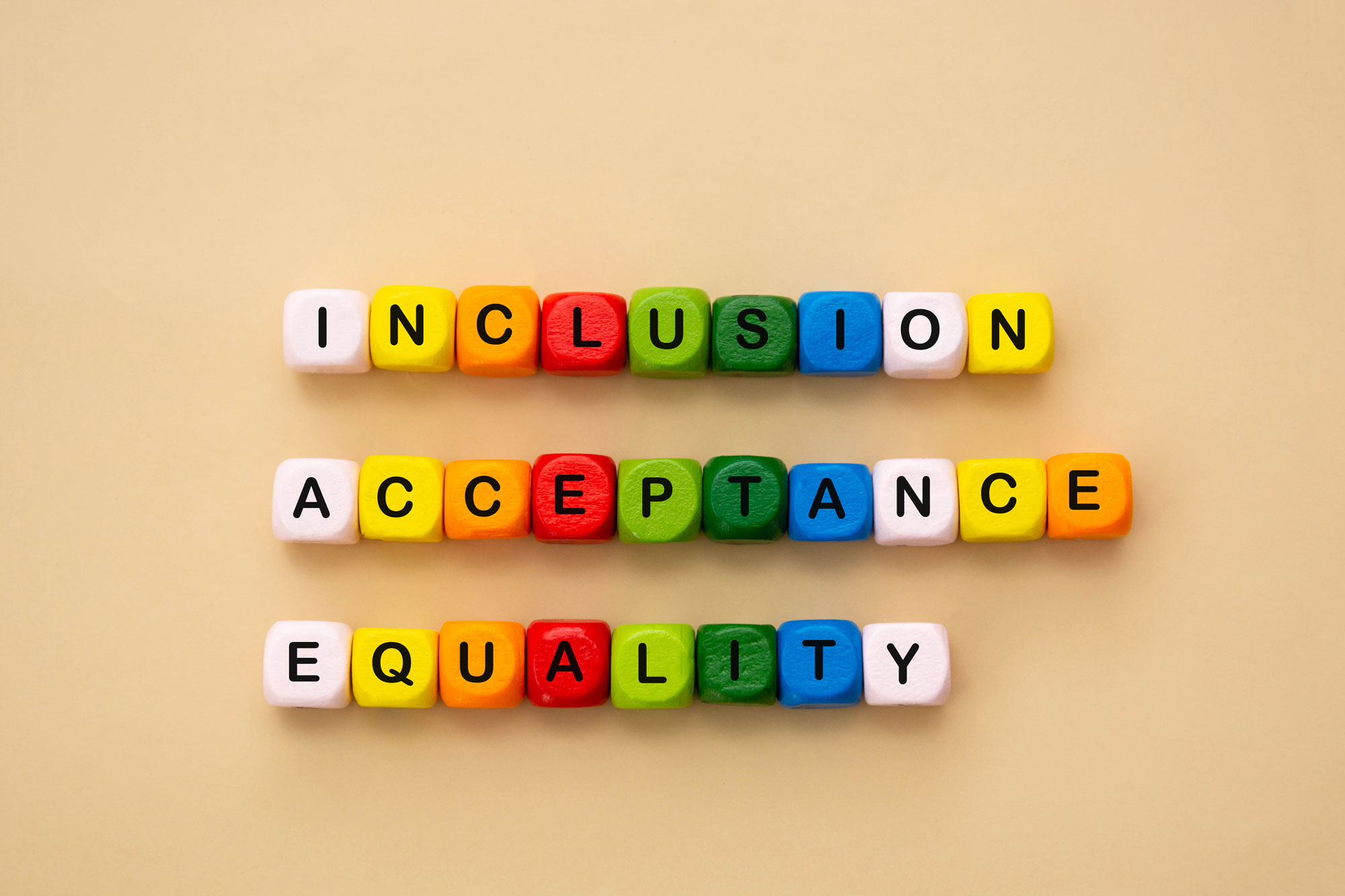 Inclusion, acceptance and equality words made from colorful wooden cubes