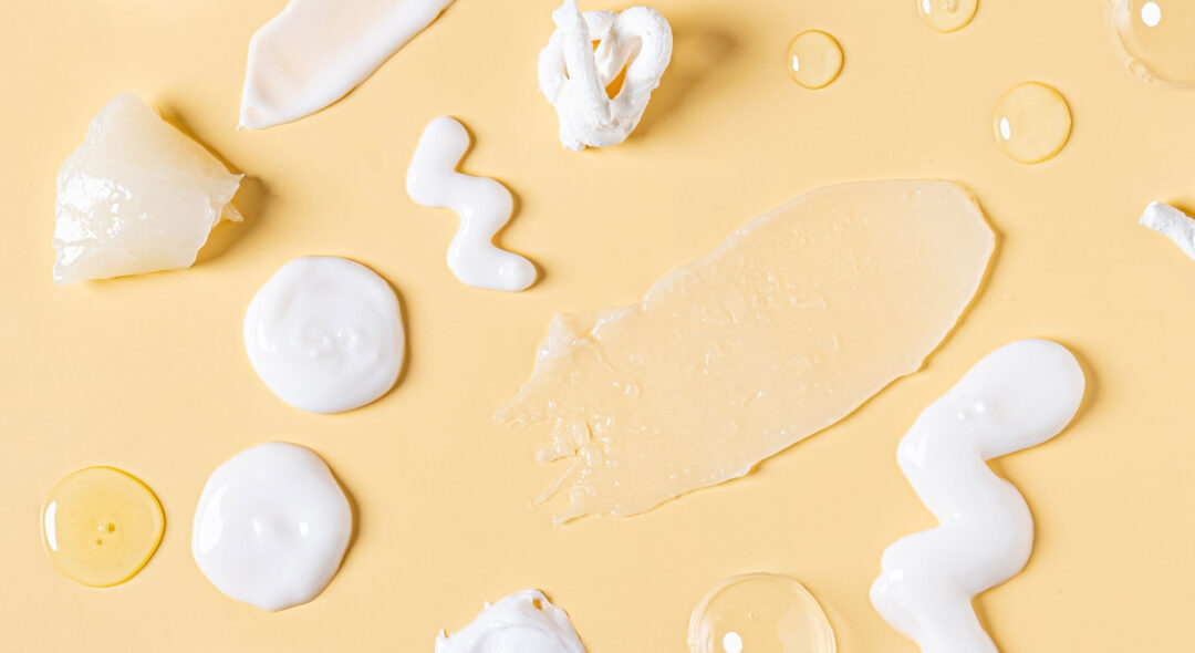 skincare products cream and oil swatches on yellow background