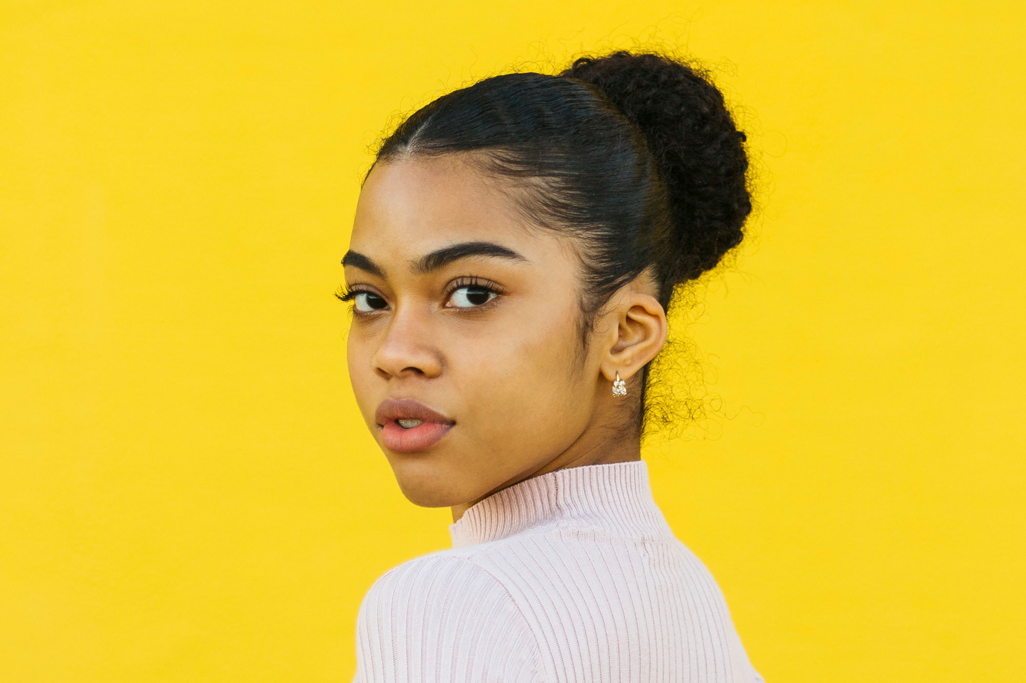 Portrait of teen posing in front of a yellow background