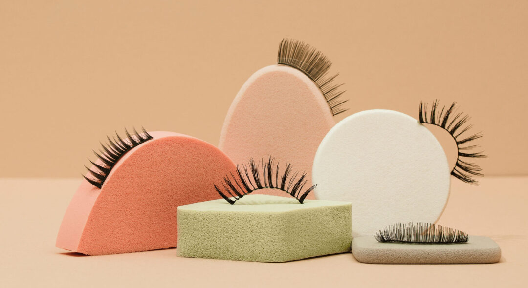 fake lashes on pedestals on tan background
