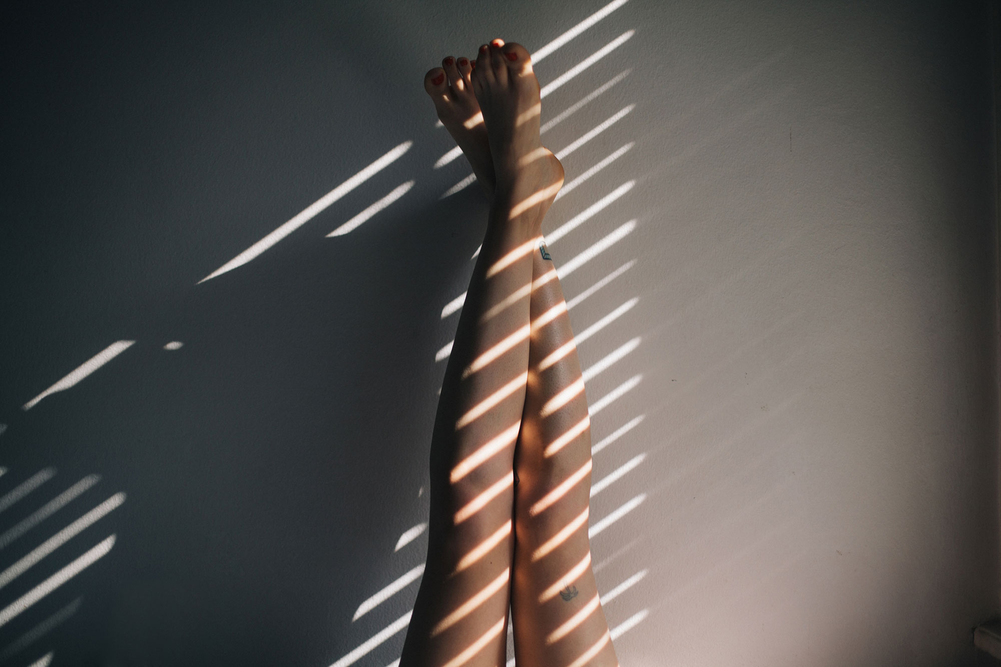legs on wall with natural light and shadows
