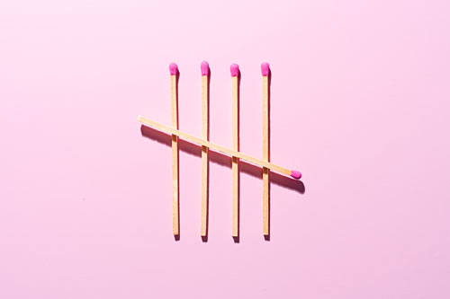 Tally Chart Composed of Matchsticks on pink background