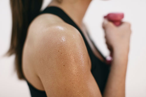 Sweaty shoulder of woman doing fitness workout