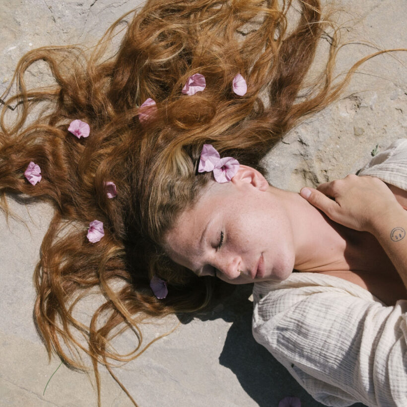 woman laying down with flowers in her hair