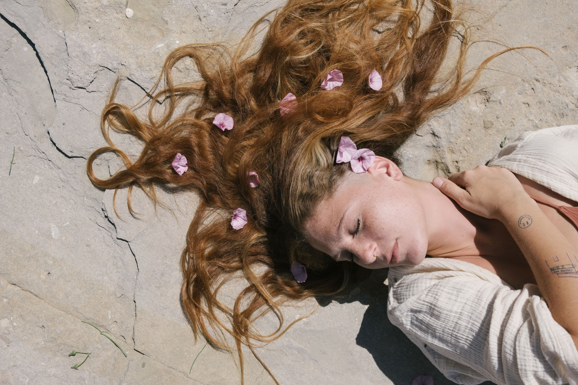 woman laying down with flowers in her hair