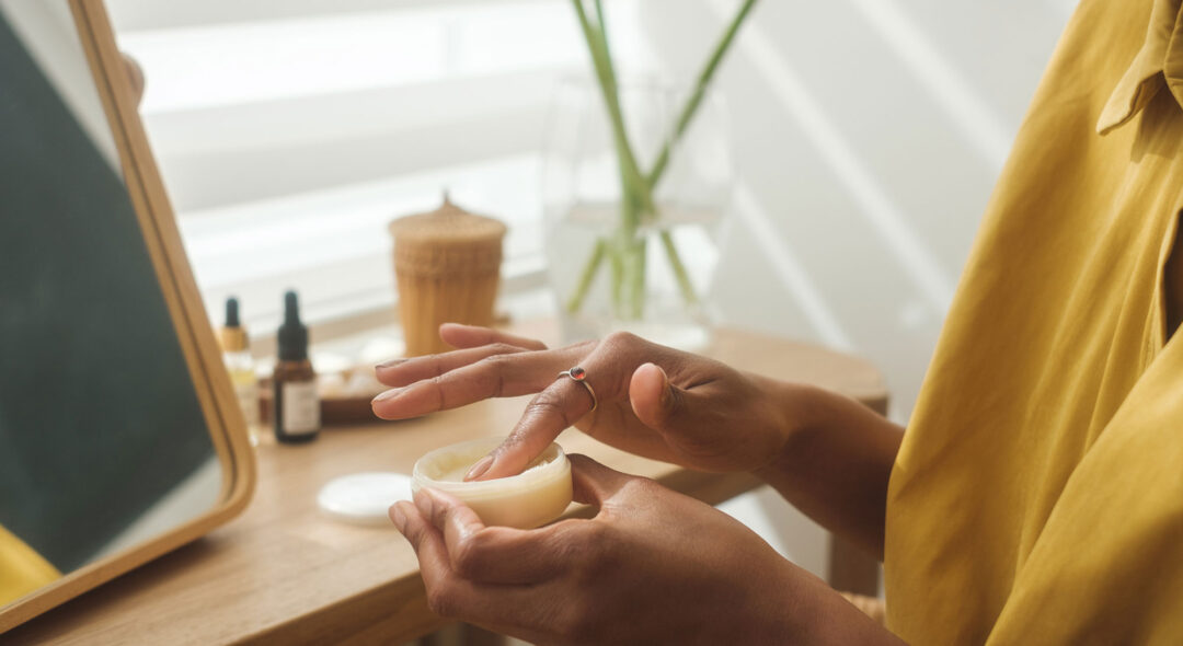 woman in vanity looking at skincare product