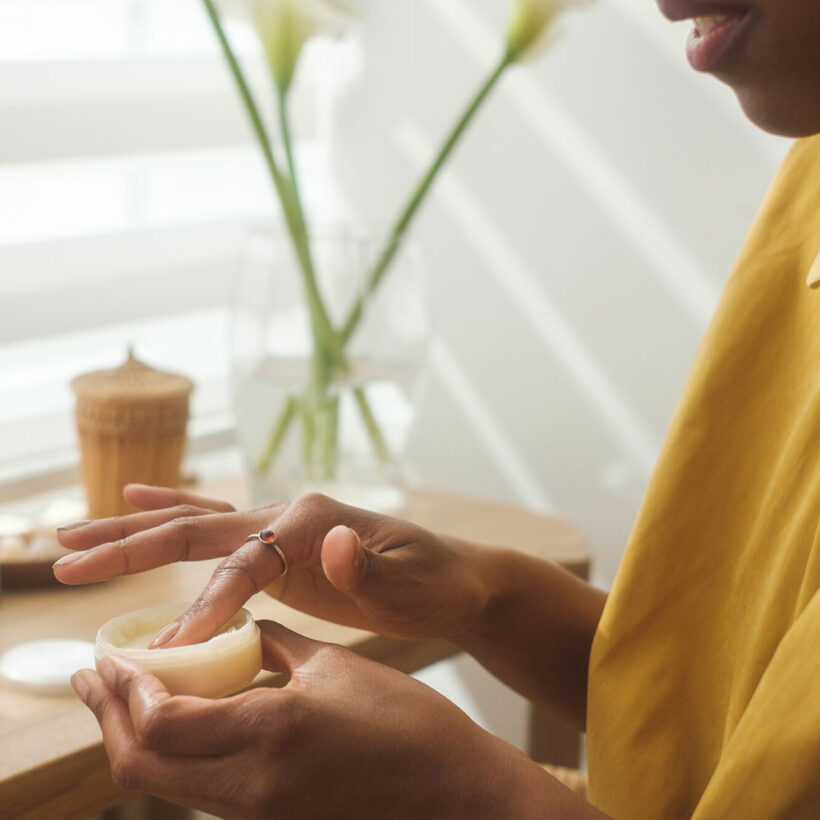woman in vanity looking at skincare product