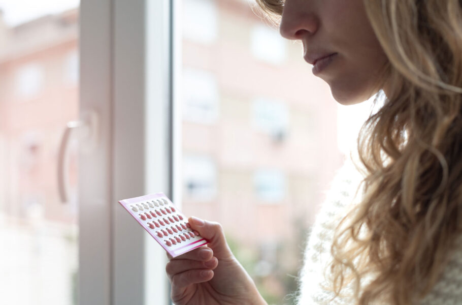 woman holding contraceptive pills at home