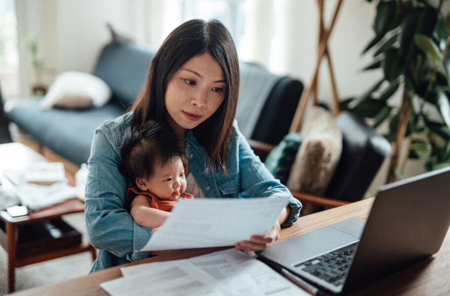 mother with baby daughter working on her laptop from home