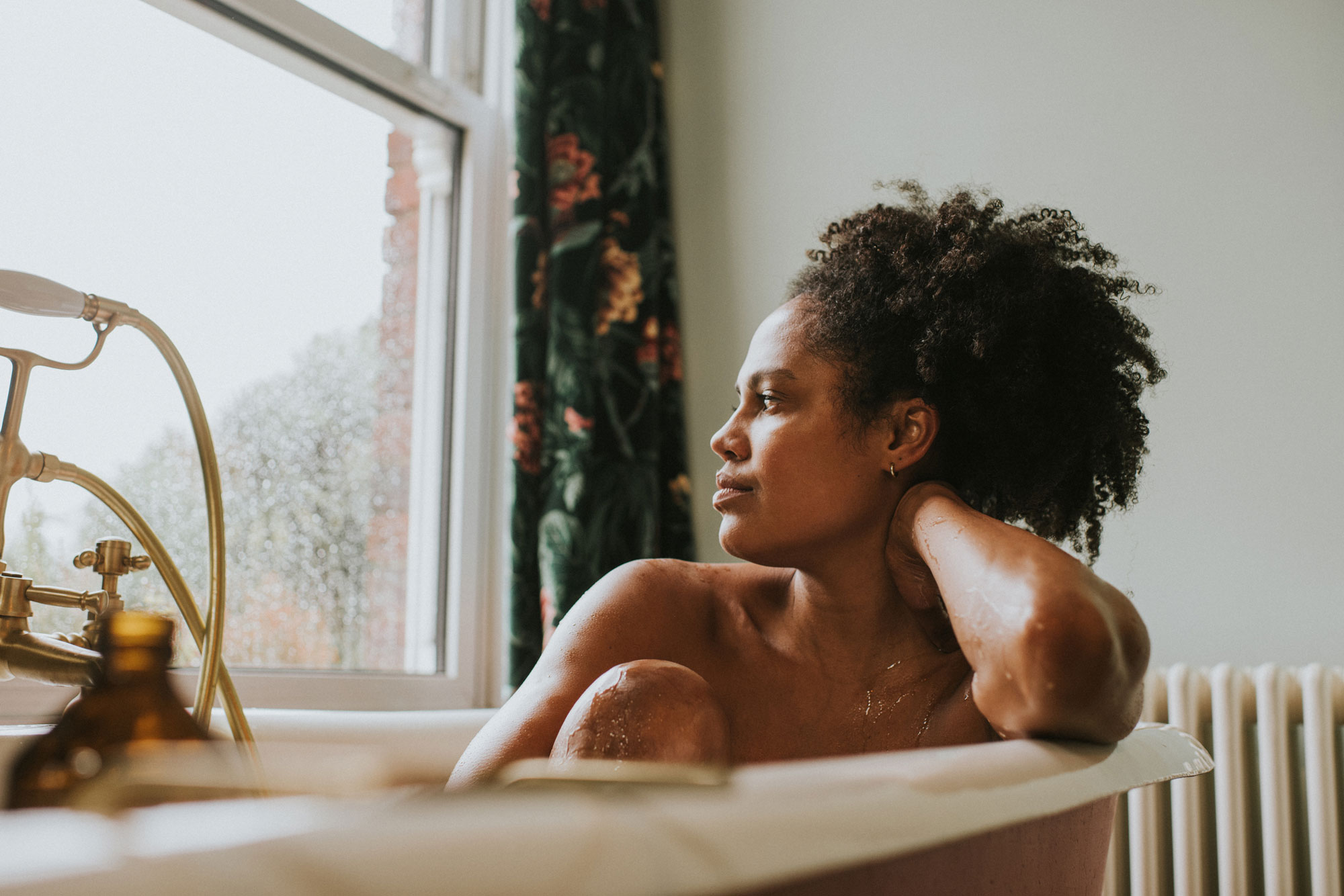 woman in tub looking out the window