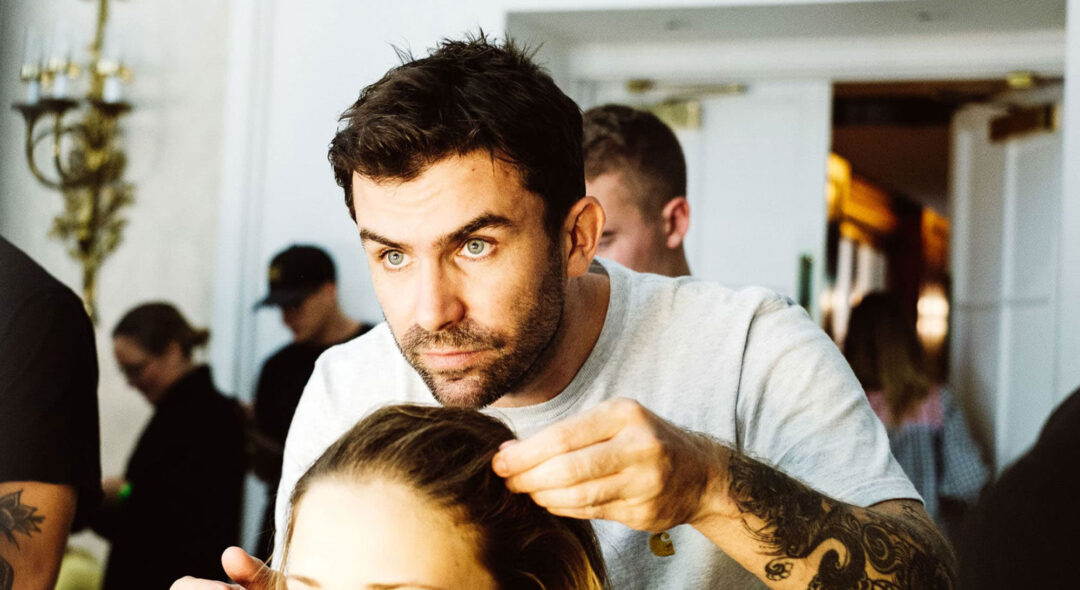 hair stylist backstage working on model's hair
