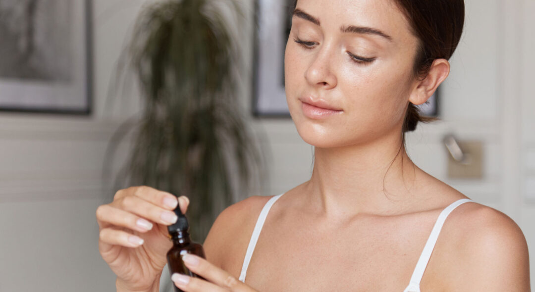 woman holding serum dropper