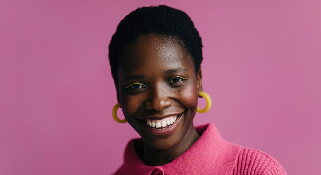 portrait of woman in pink studio background with bright makeup