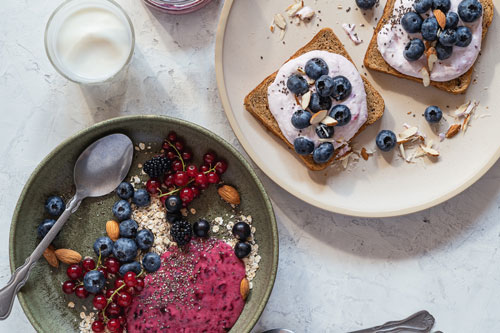 Toasts with cream cheese, fresh blueberries and smothie bowl with fresh berries, breakfast