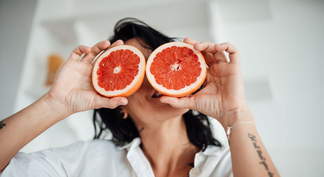 Woman Holding Grapefruit Slice At Home