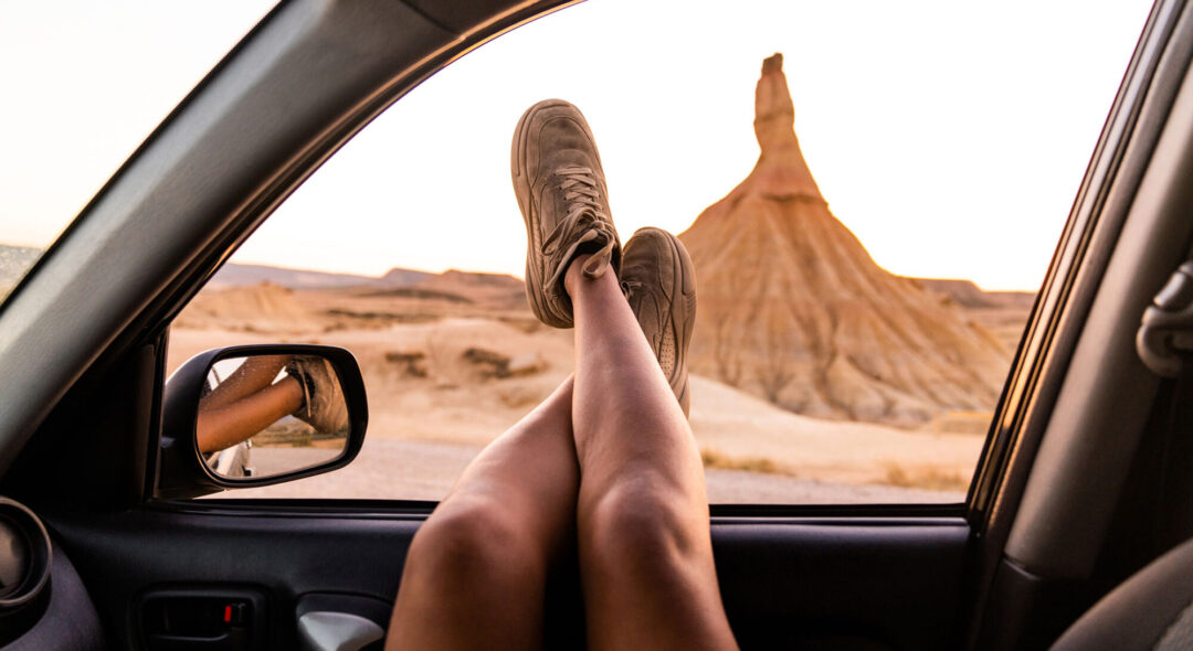crossed legs of a woman out of the car window